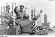 Парад нямецкай паліцыі аховы грамадскага парадку ў Мінску, 1943 г. На заднім плане — драўляная плябанія і касцёл